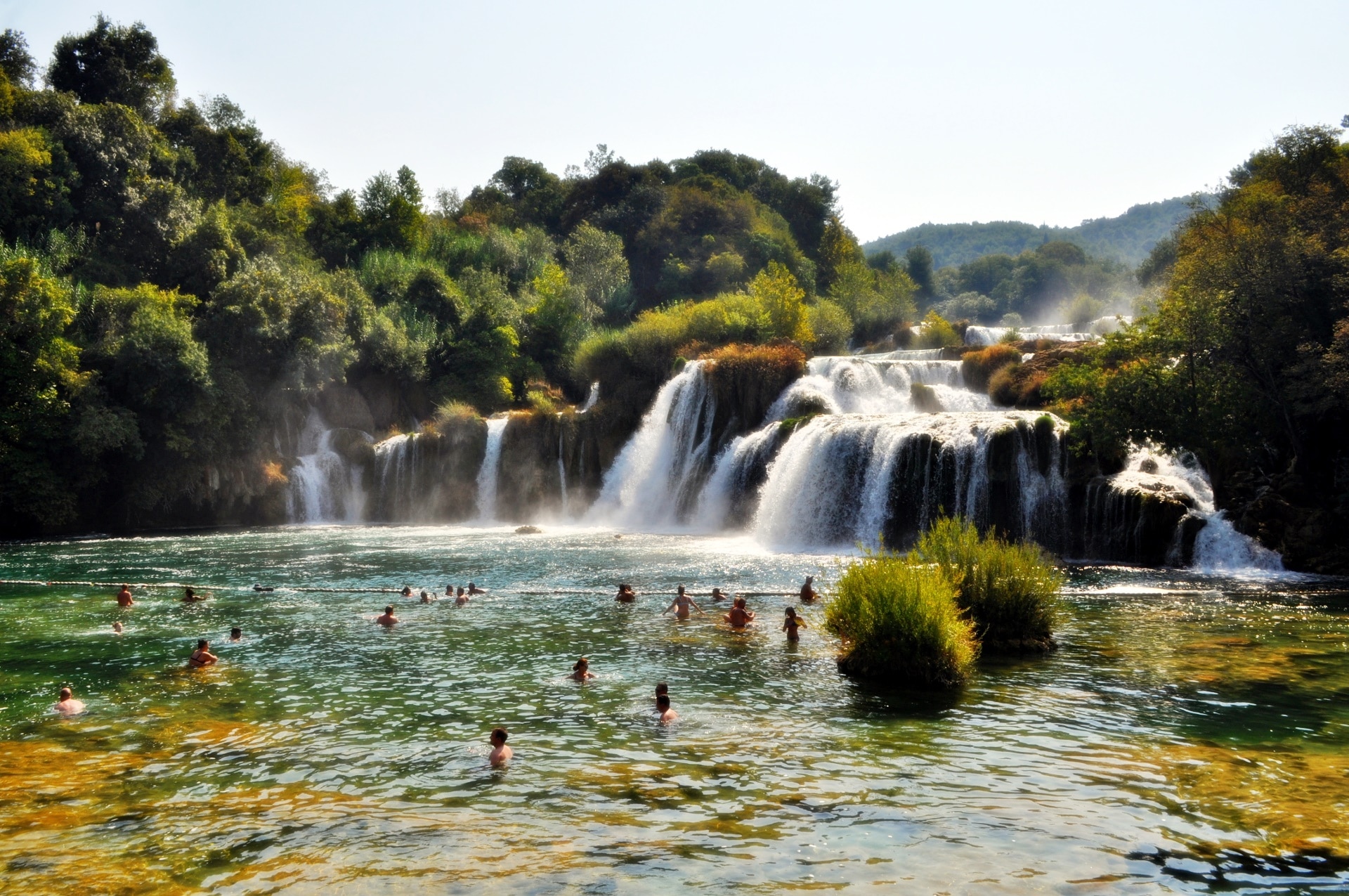 group of people on body of water near waterfalls during daytime