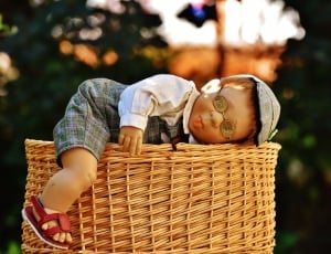 baby doll and brown wicker basket thumbnail
