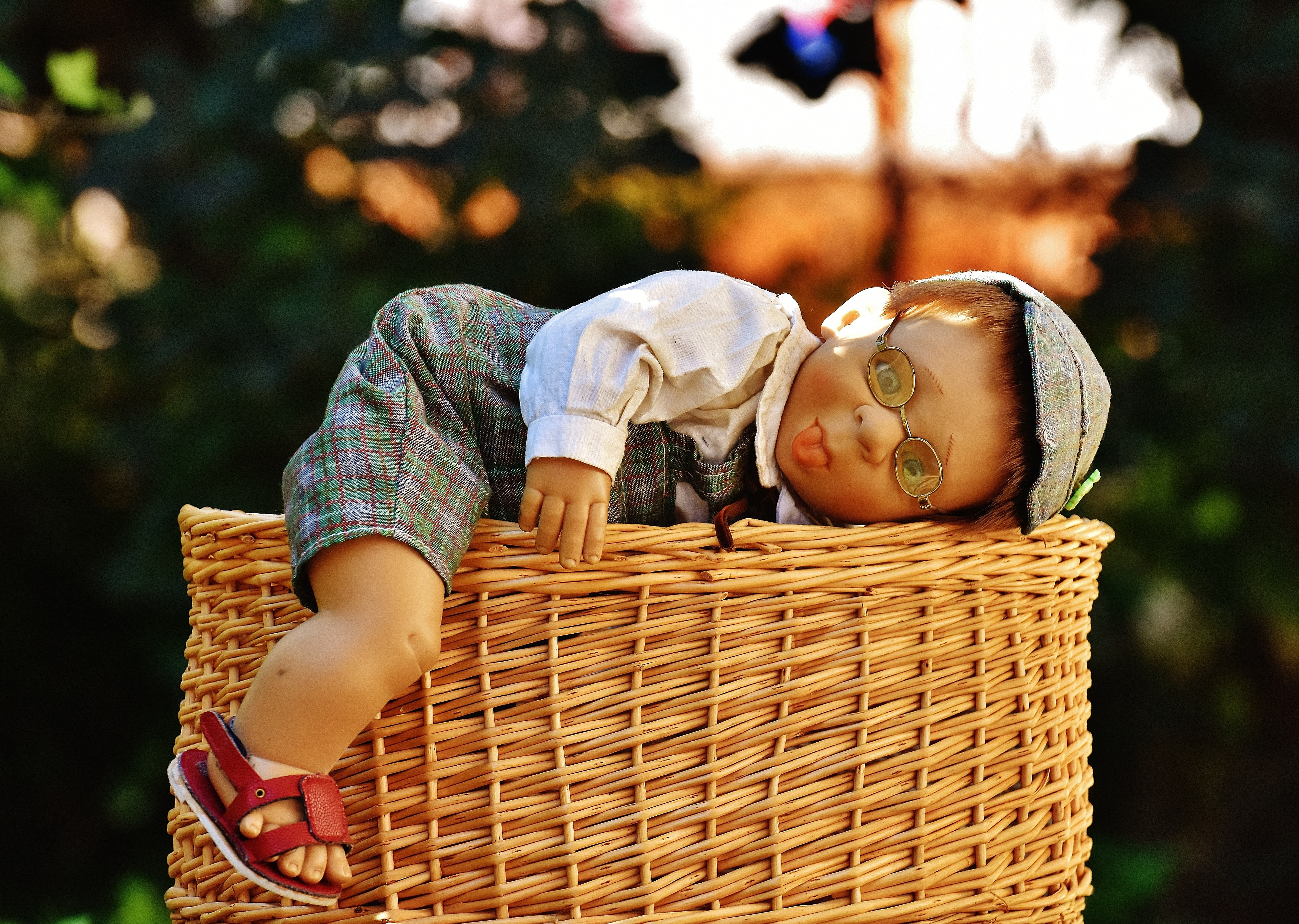 baby doll and brown wicker basket