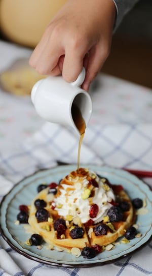 selective focus photo of waffle with whip cream and raisin on ceramic plate thumbnail