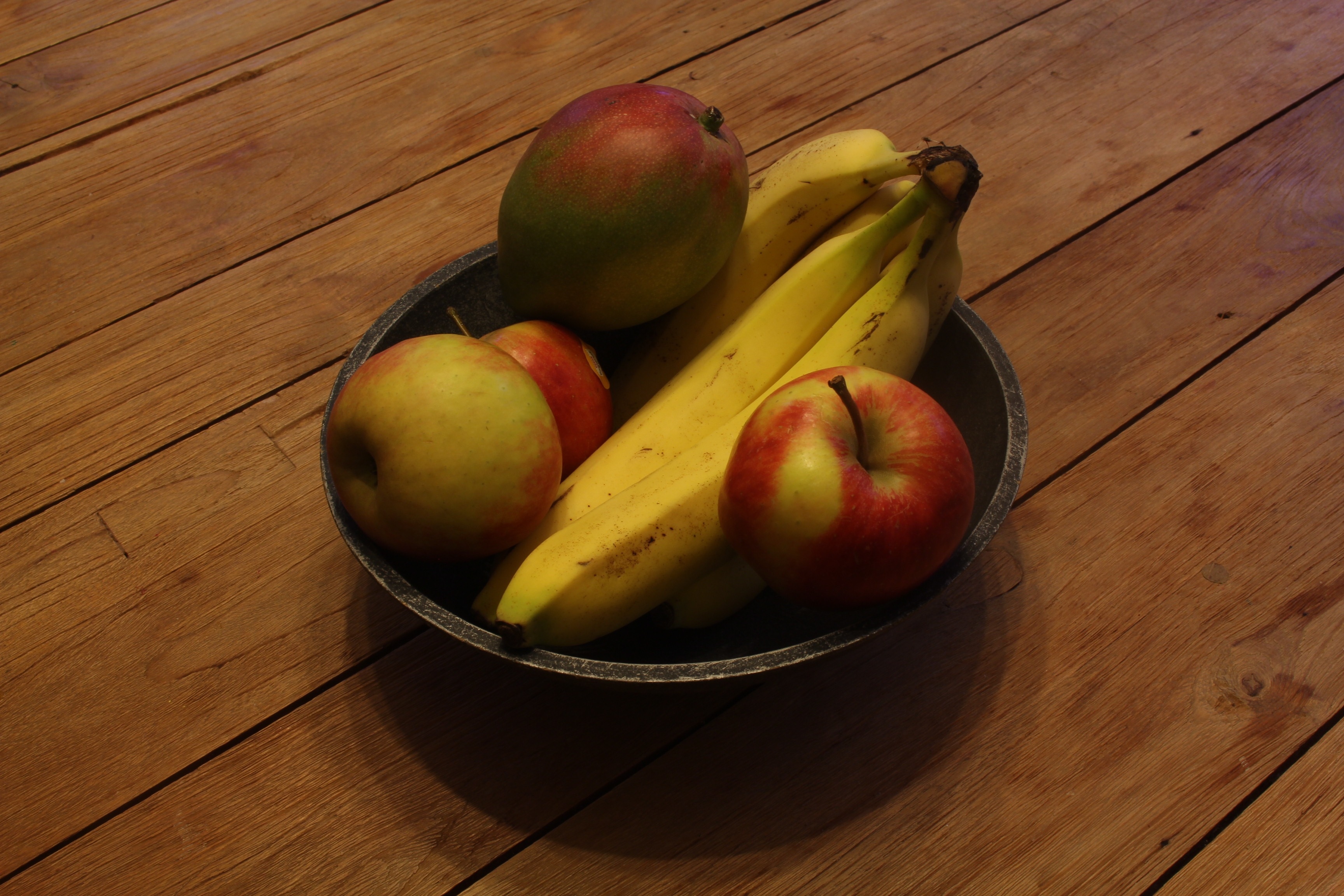 4 red apples and 4 bananas on black bowl