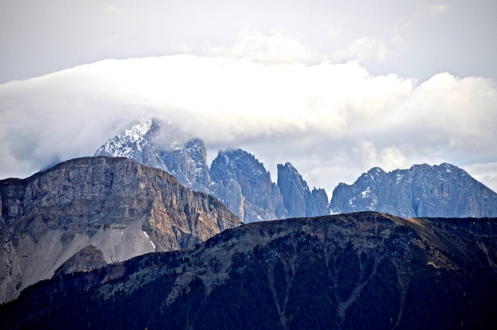 gray mountains filled with snow under the white cloudy sky preview