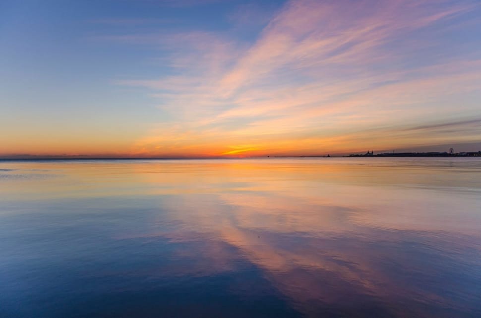 reflection of orange clouds on body of water during golden hour preview