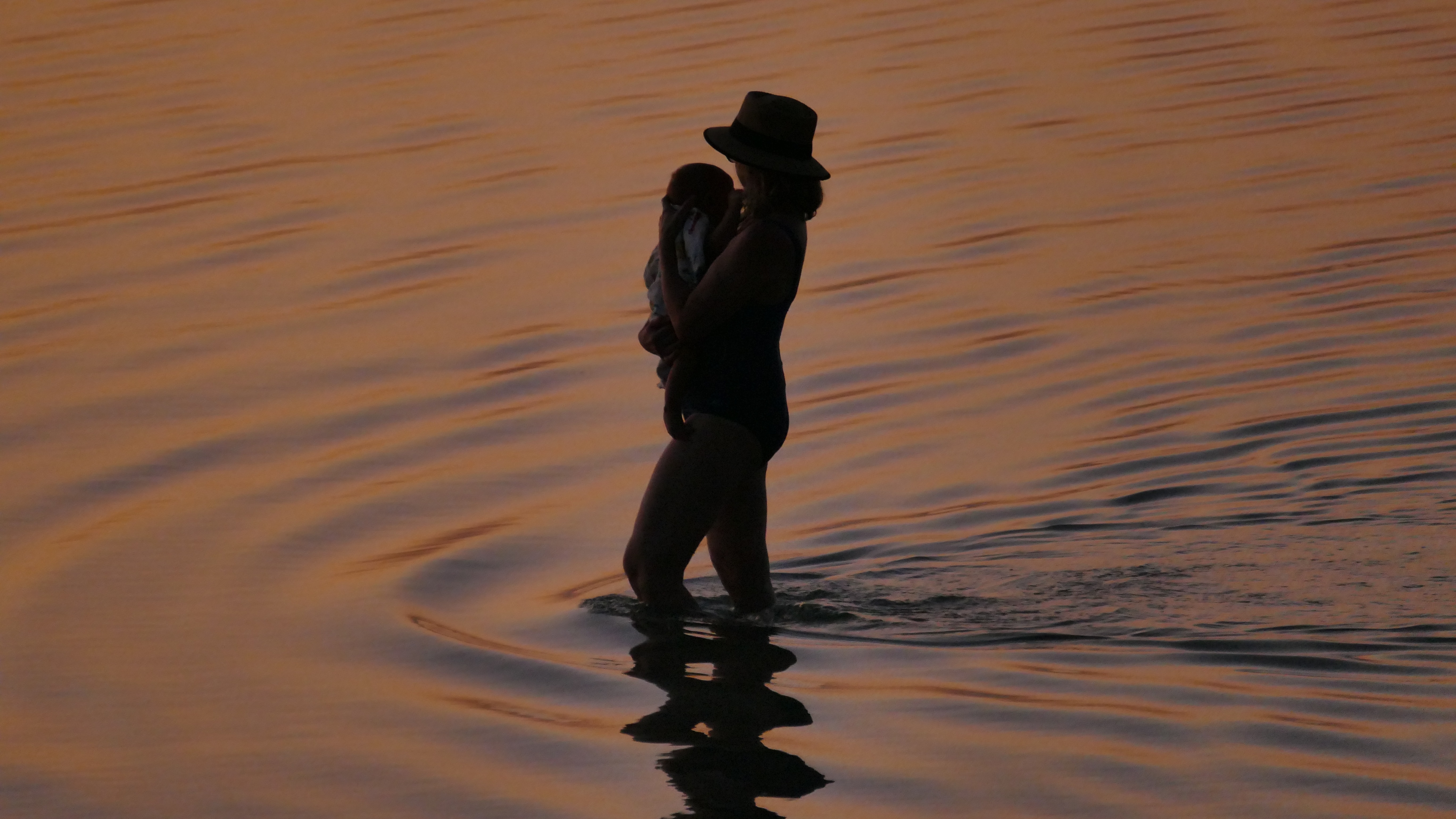 woman carrying her baby at the lake