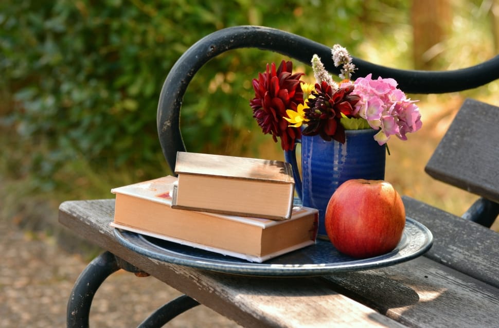 red apple fruit and red pink and yellow floral bouquet and 2 books preview