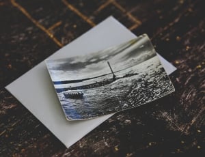 grey scale photo of boat on water thumbnail