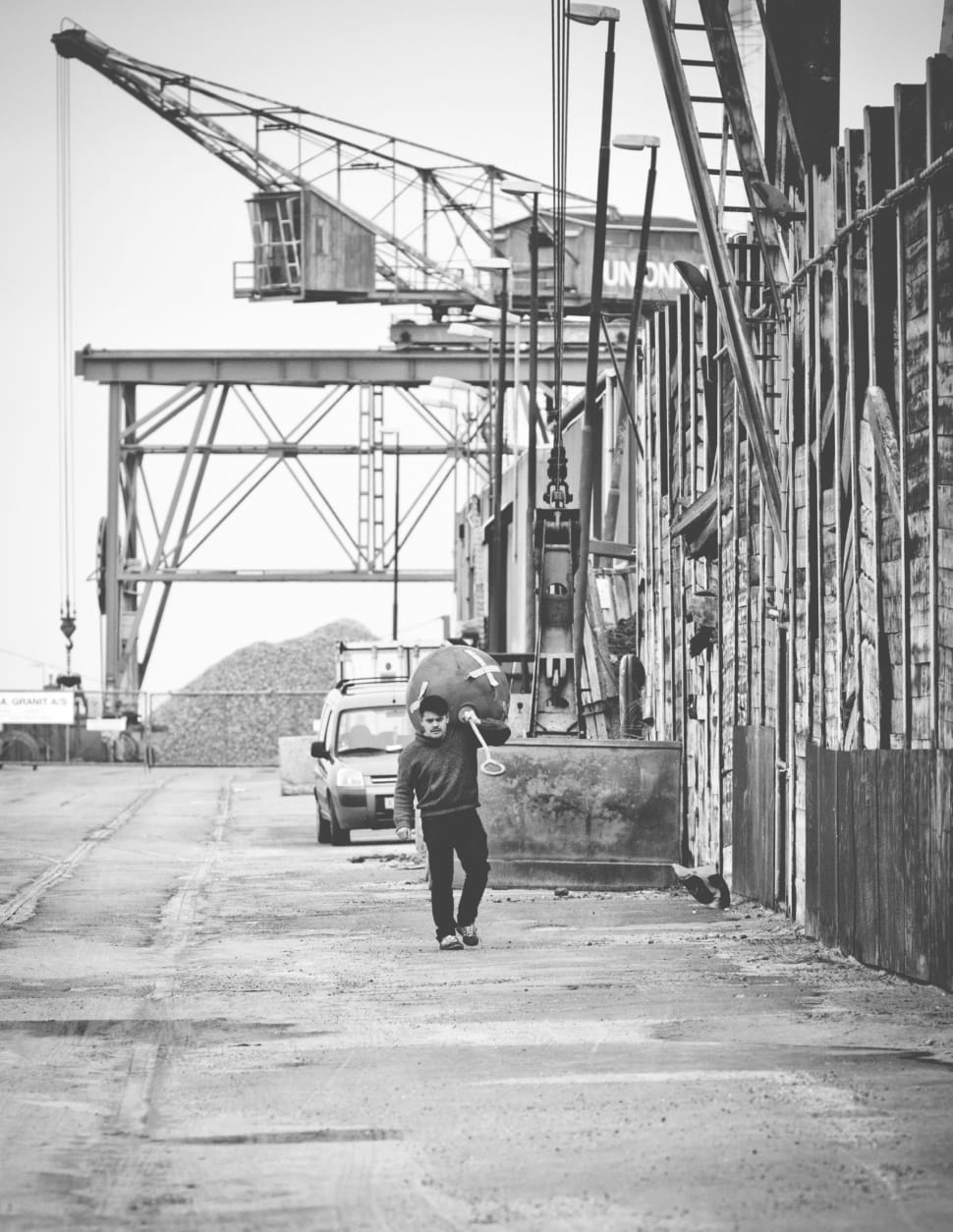 man carrying metal equipment grayscale photo preview