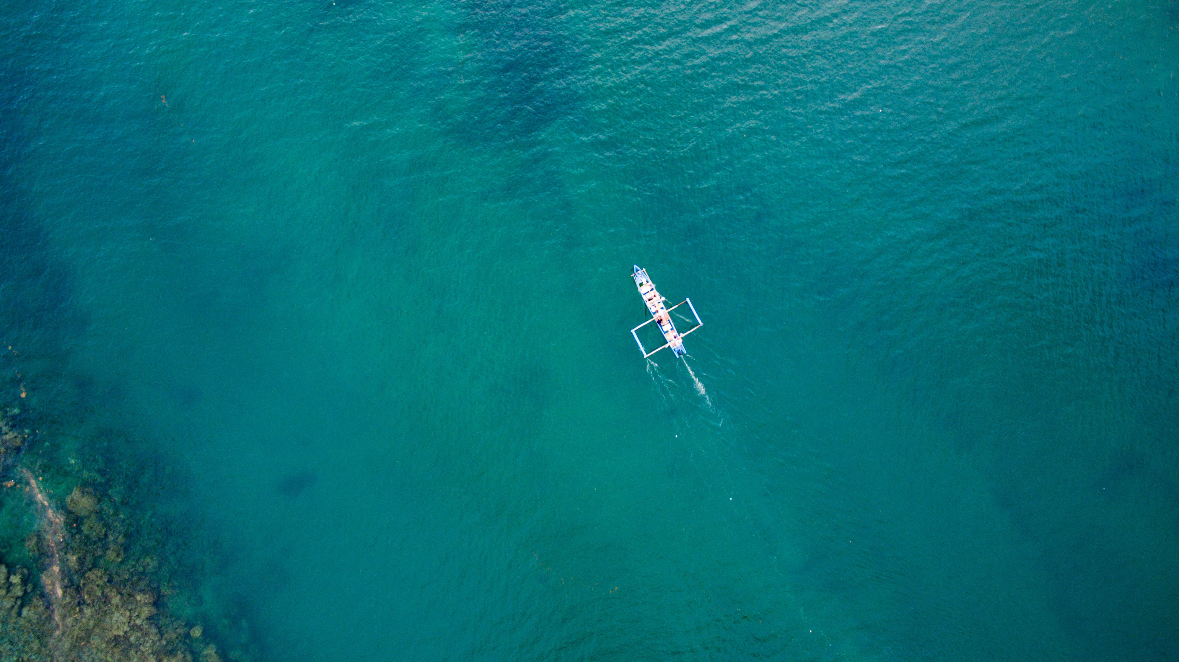 aerial shot of white sailing boat on water