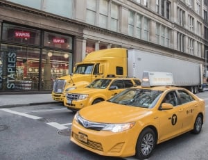 three yellow vehicles on daytime thumbnail