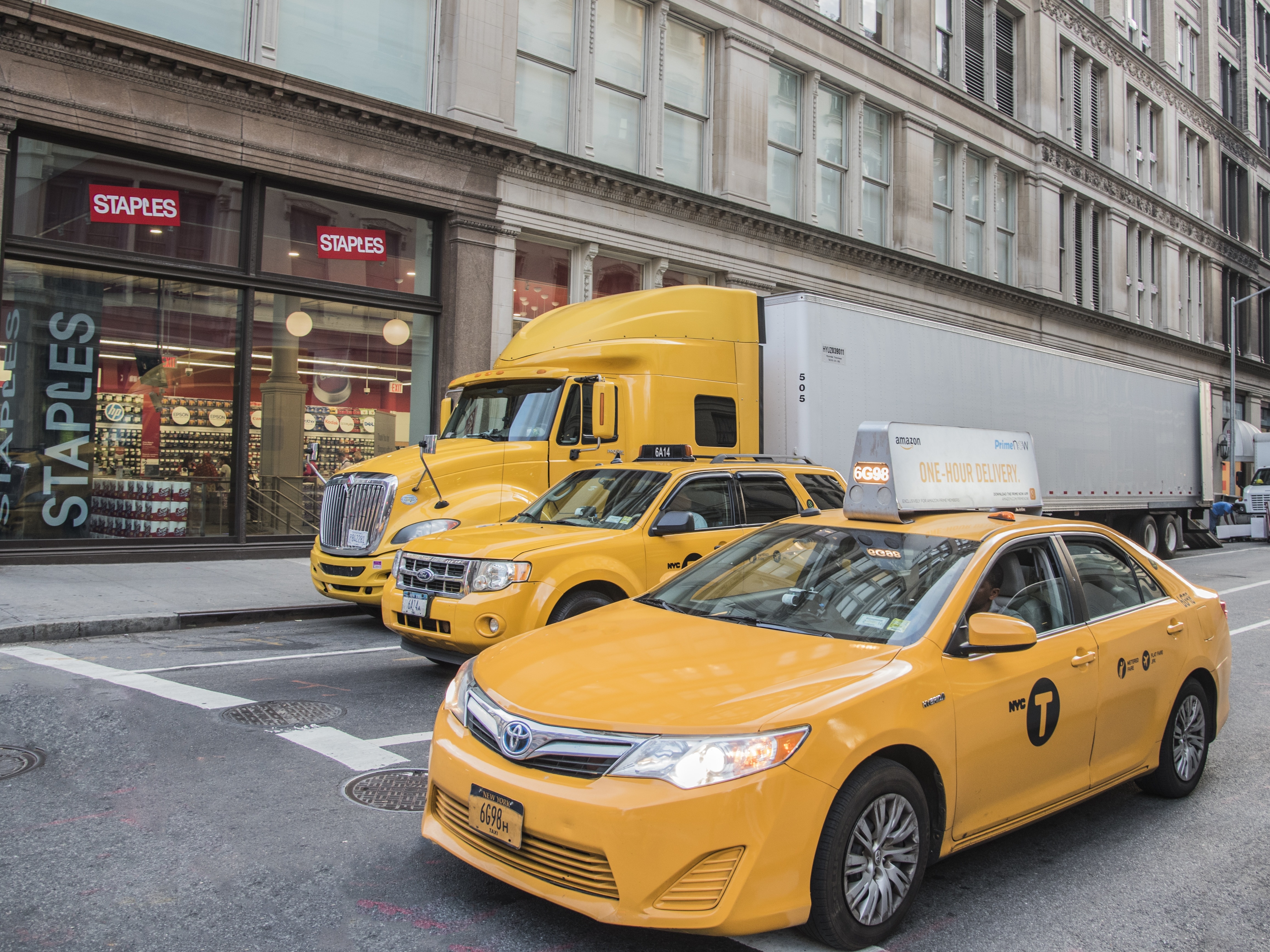 three yellow vehicles on daytime