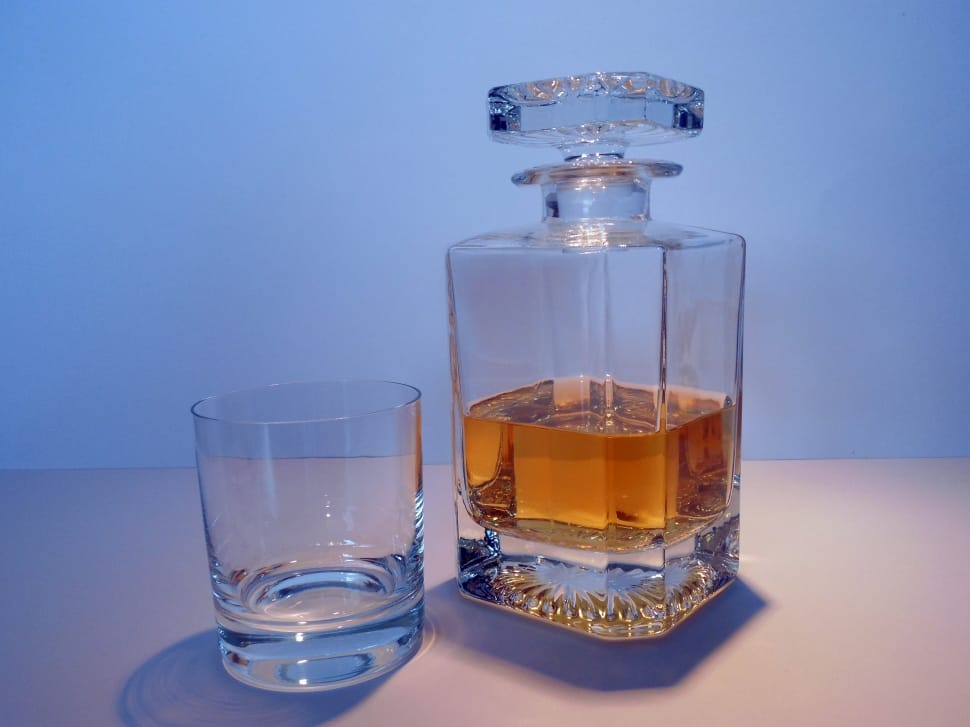 brandy inside clear glass decanter beside clear shot glass preview