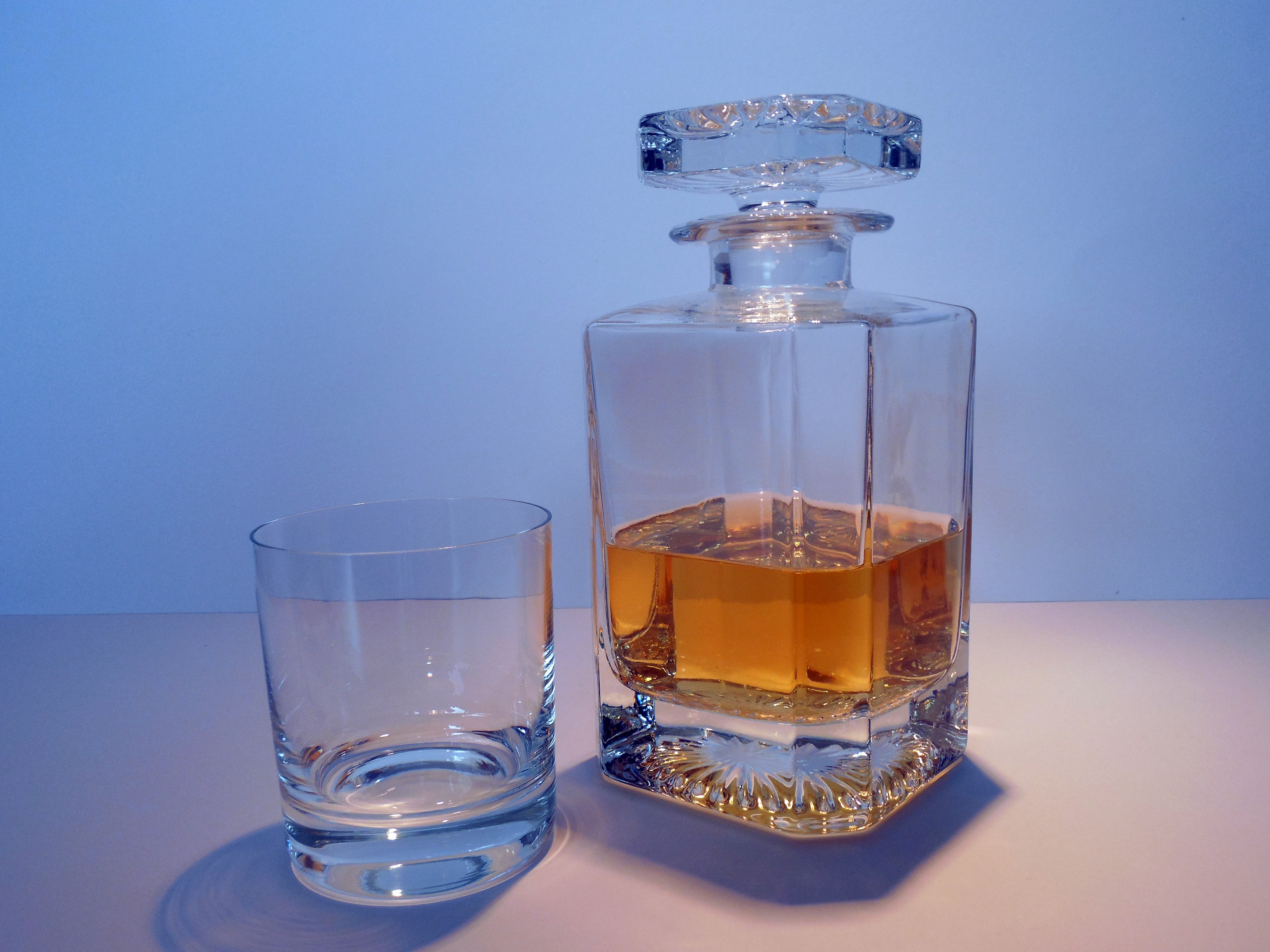 brandy inside clear glass decanter beside clear shot glass