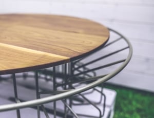 close-up of stainless steel frame brown wooden round table thumbnail