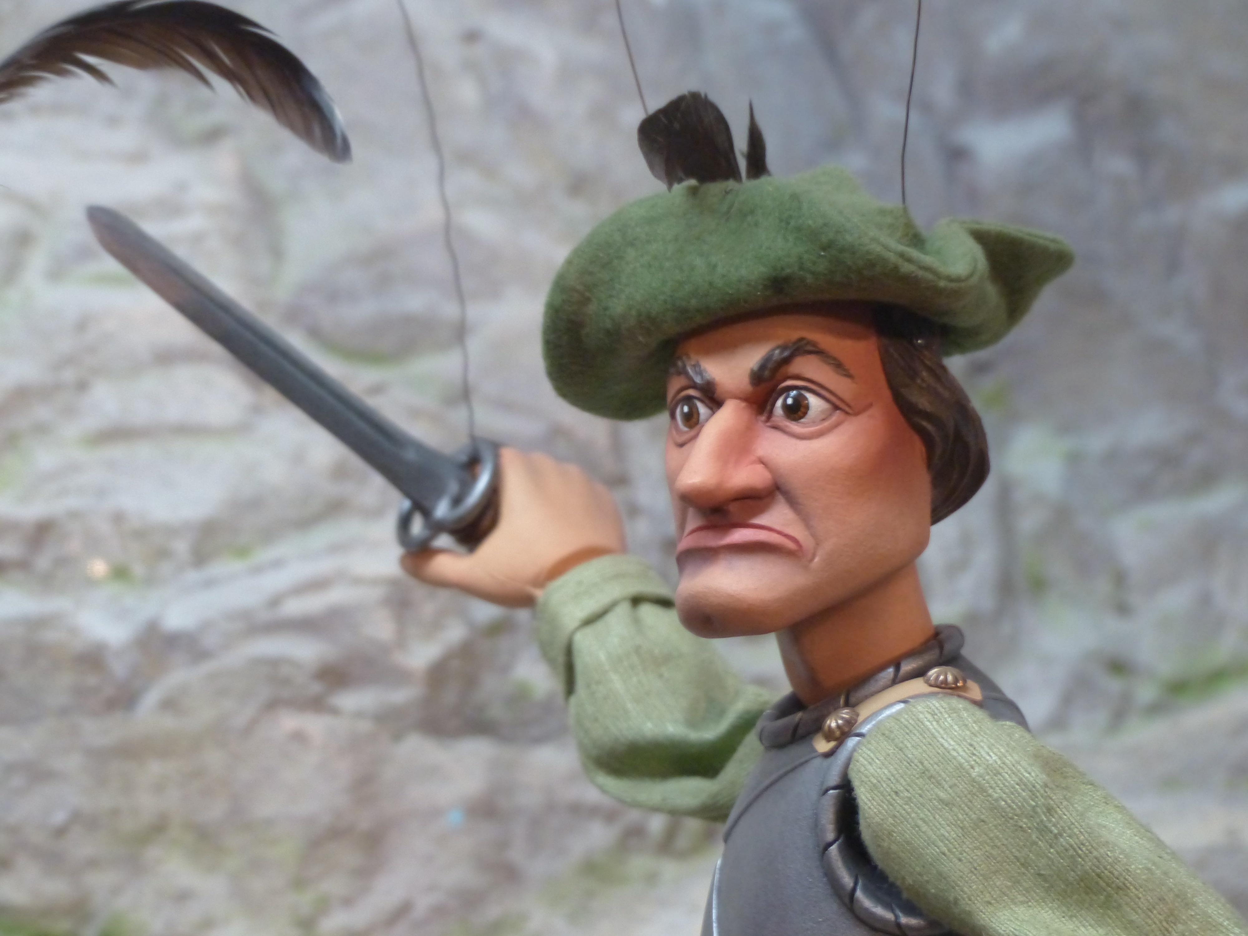 man in green hat holding sword puppet