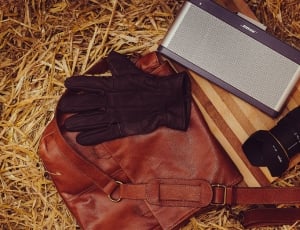 brown leather crossbody bag and black dslr camera lens thumbnail