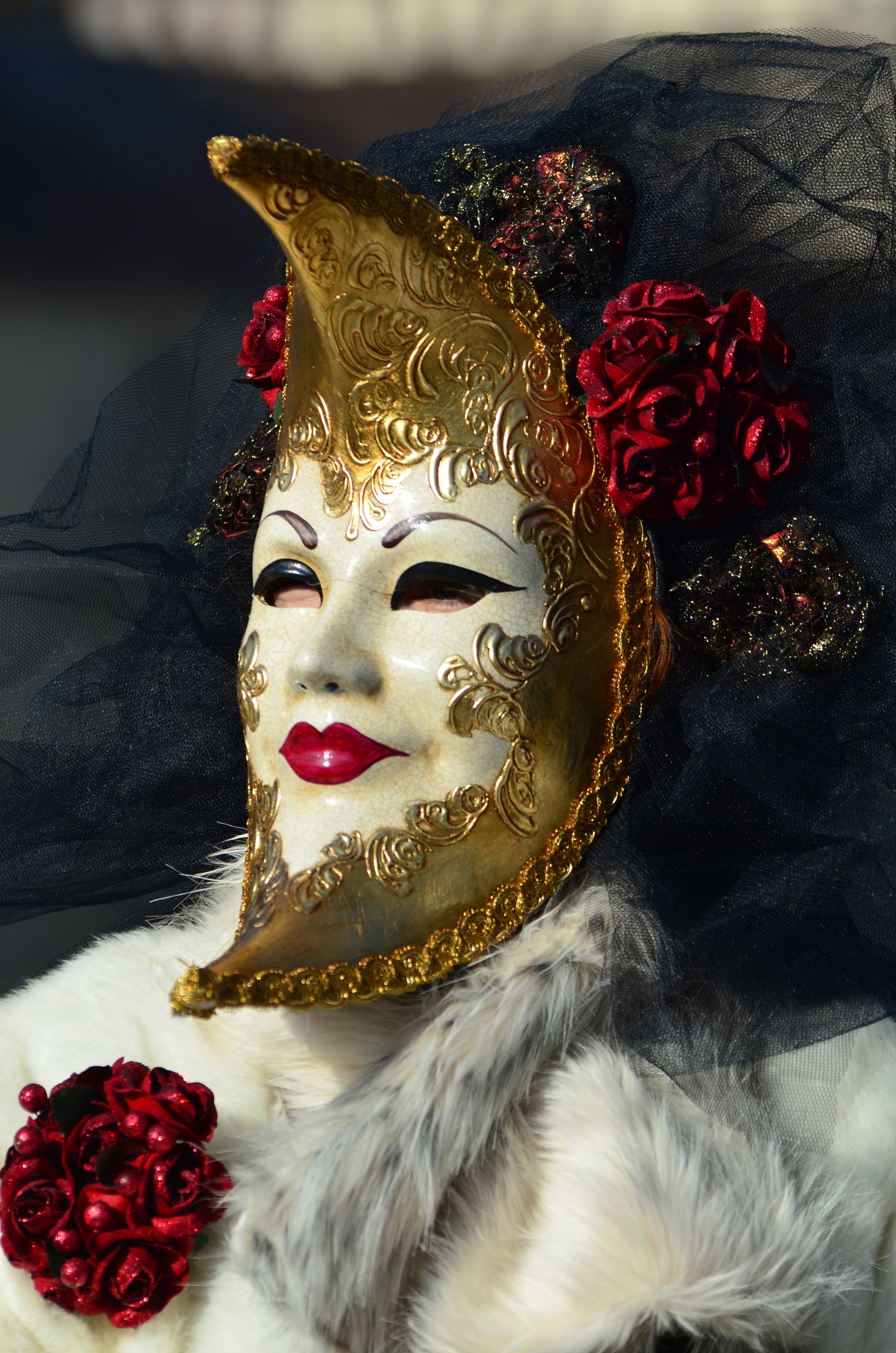 person wearing white and gold floral volto mask