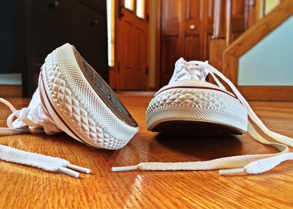 white low top sneakers on parquet floor preview