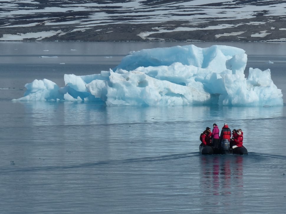 group of people riding on black inflatable boat near snow island during daytime preview