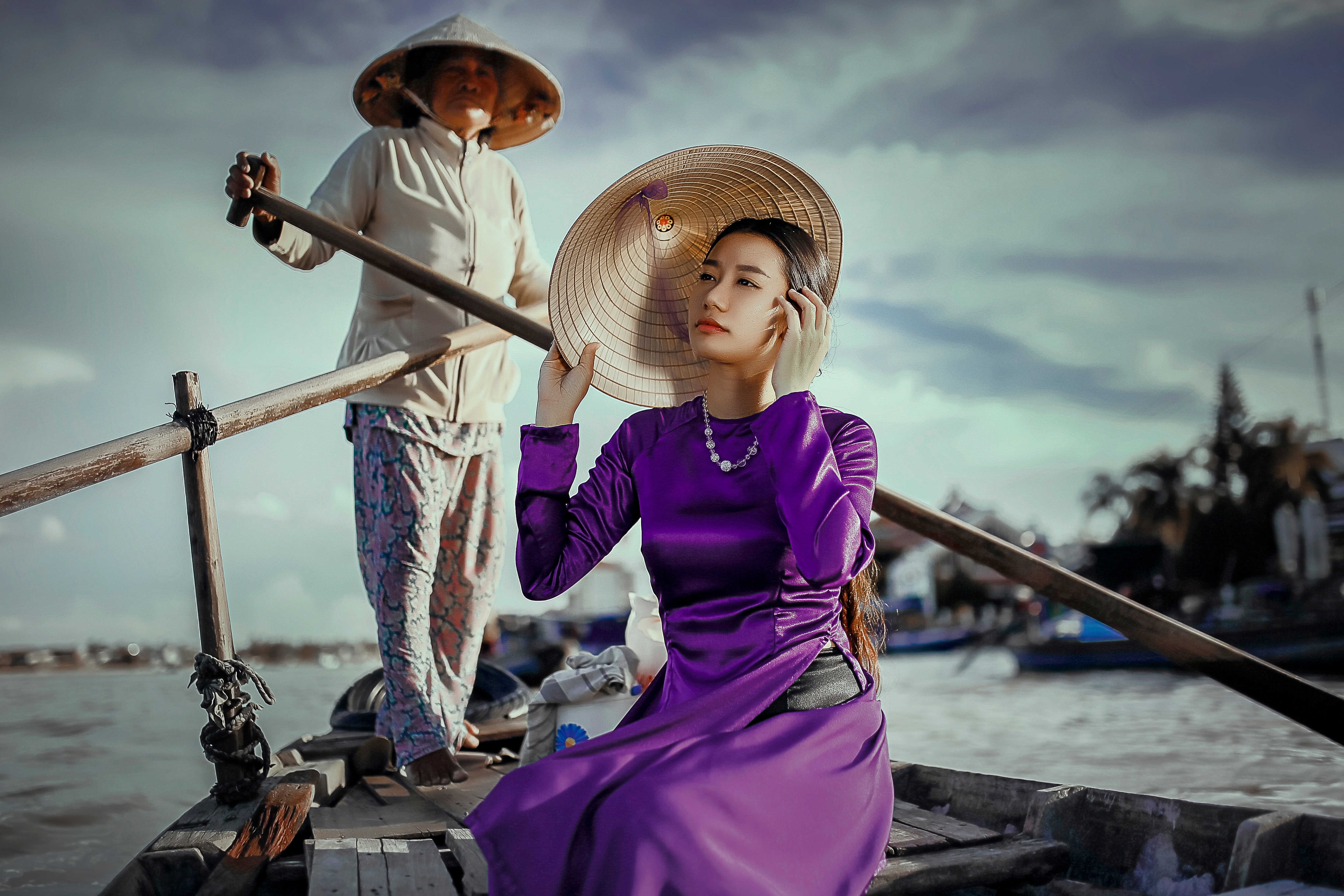 man paddling the boat while woman riding in purple long sleeve dress and holding brown hat