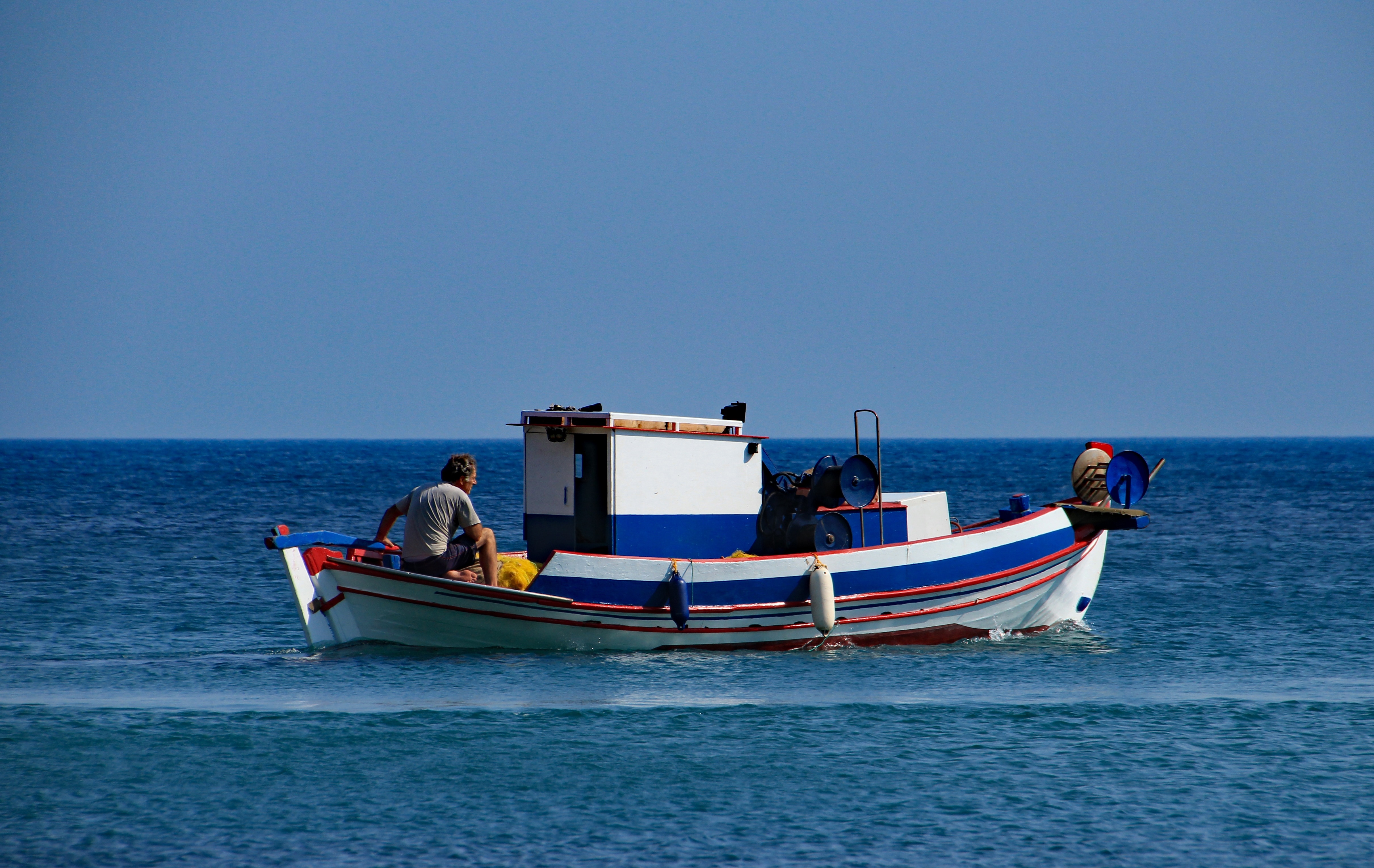 white blue and red small fishing boat