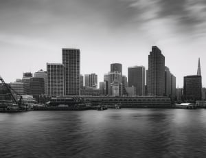 gray scale photo of city with small body of water thumbnail