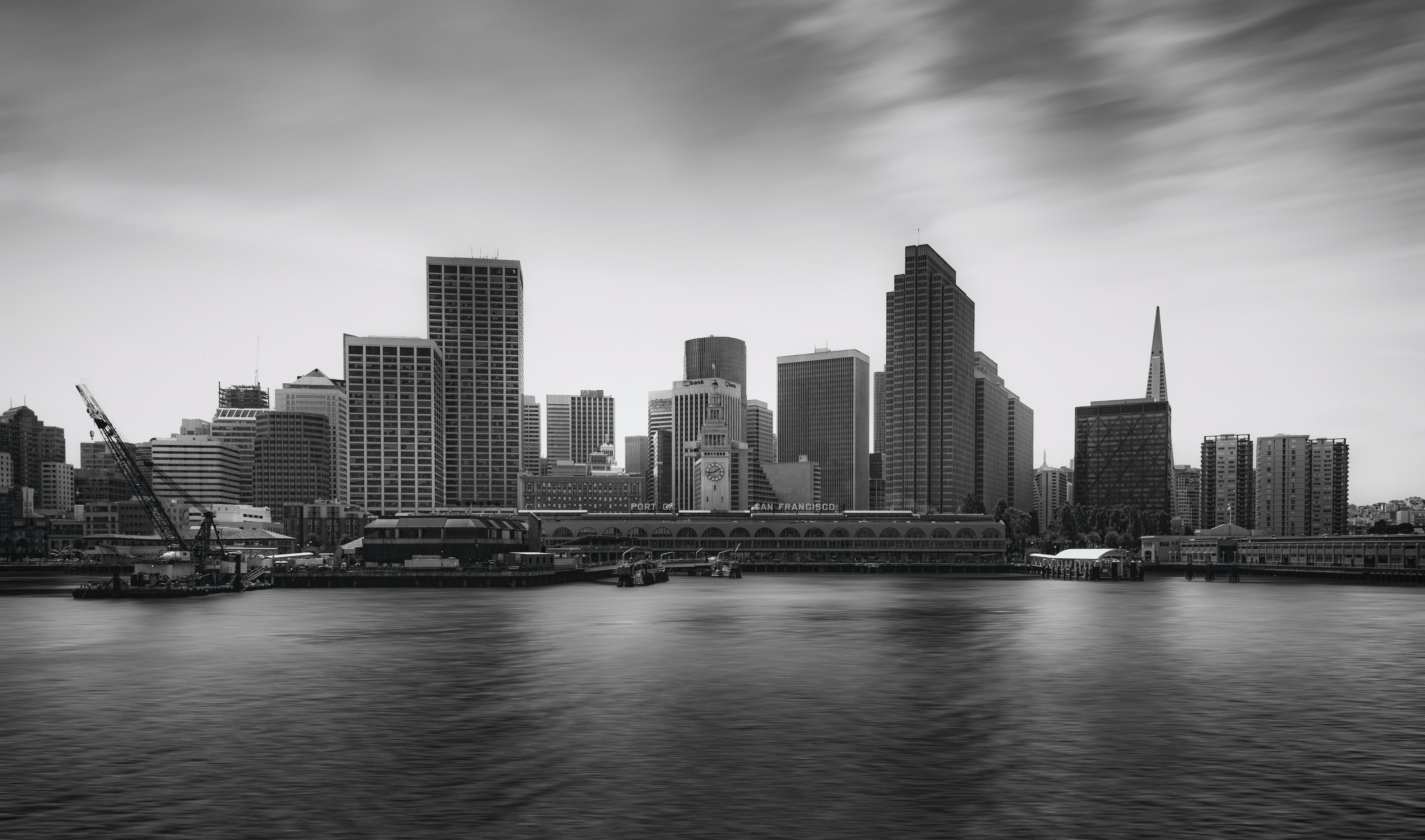 gray scale photo of city with small body of water