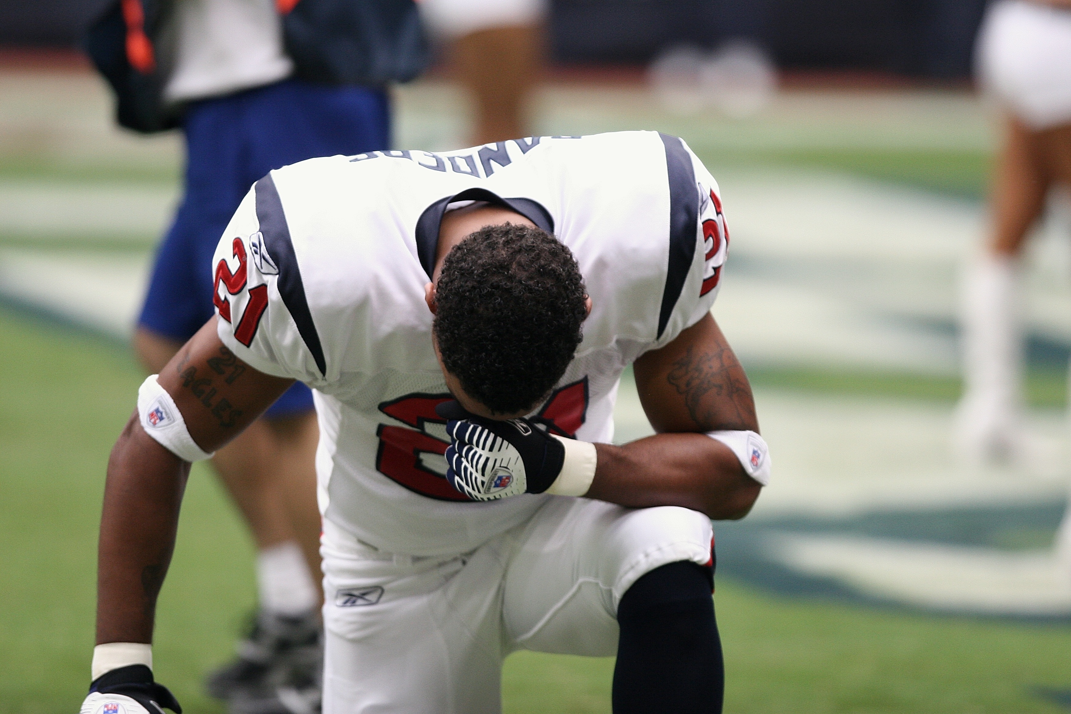 american football player in white and red jersey kneeling