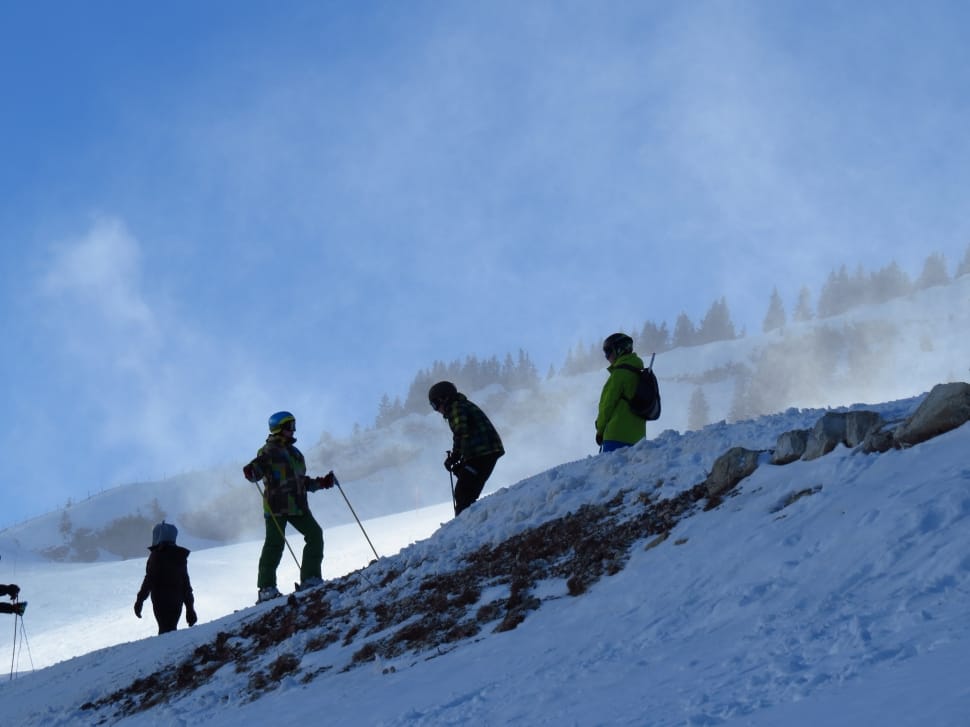 four persons skiing on snow capped mountain during day preview