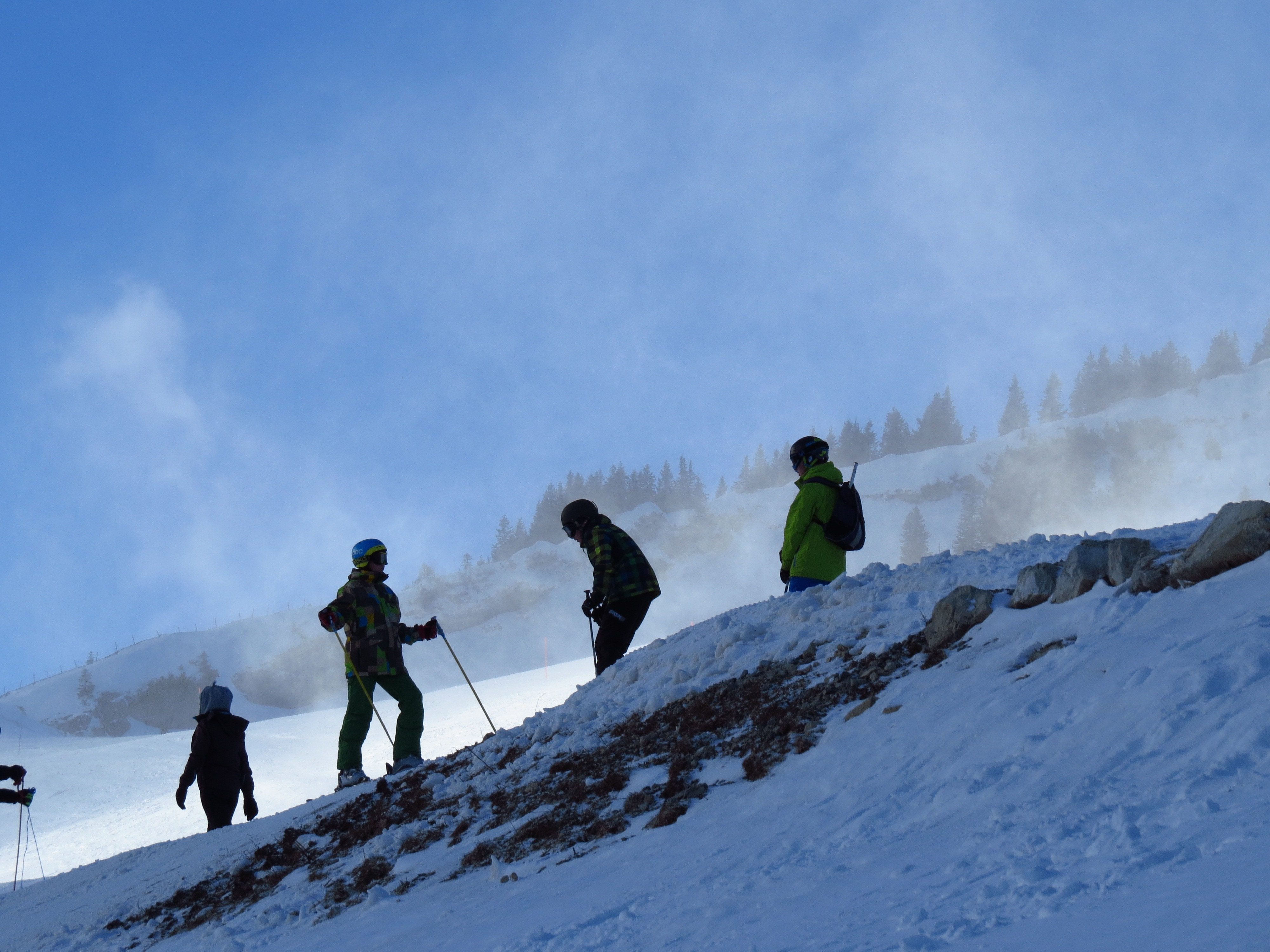 four persons skiing on snow capped mountain during day