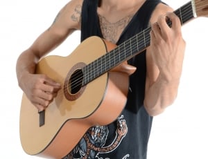 man in black tank top playing guitar thumbnail