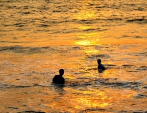 two men in body of water during sunset thumbnail