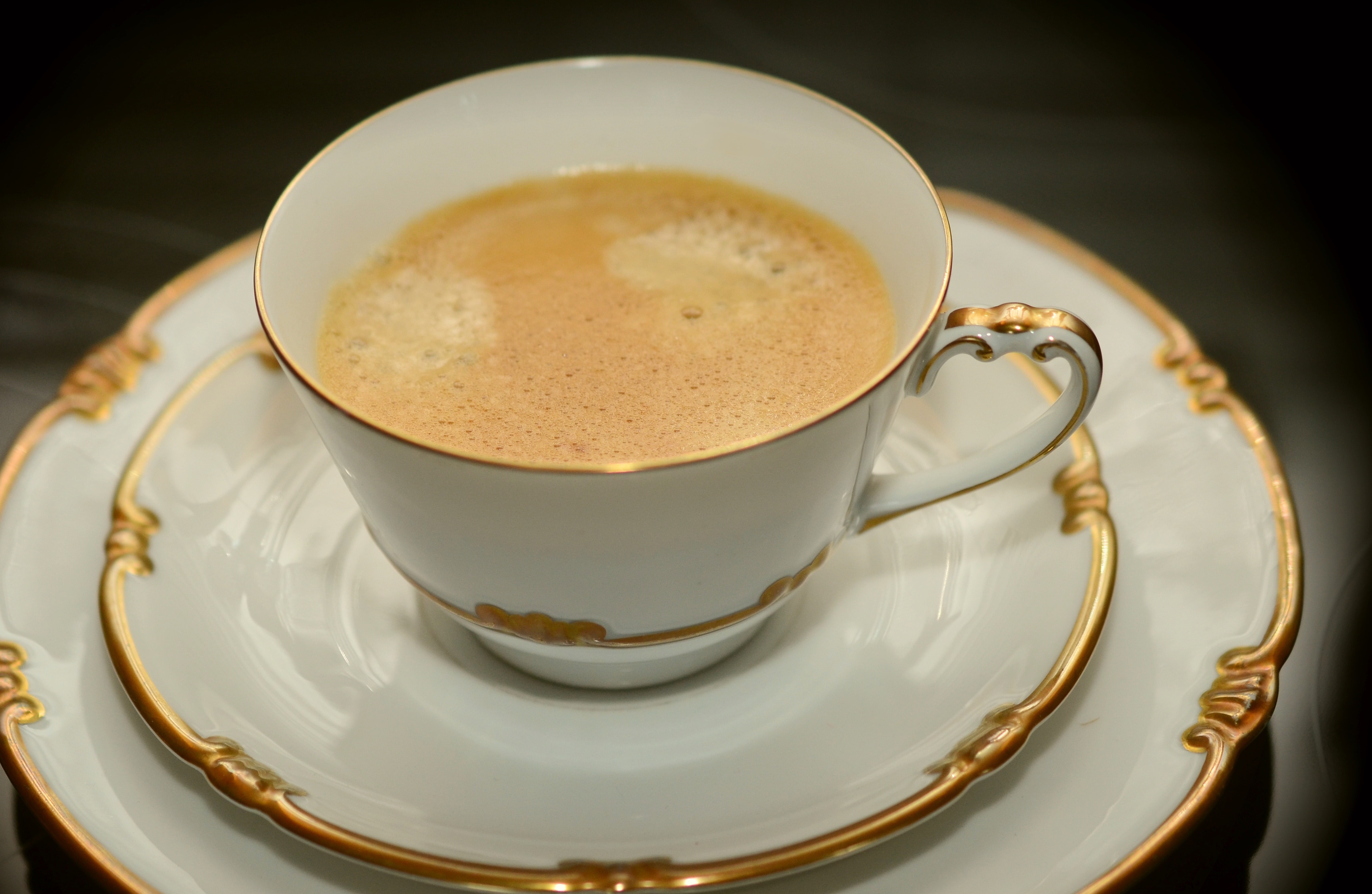 white ceramic and gold rim teacup