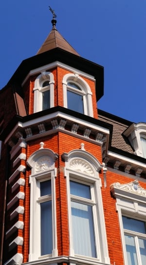 low angle photography of white and orange high rise establishment thumbnail
