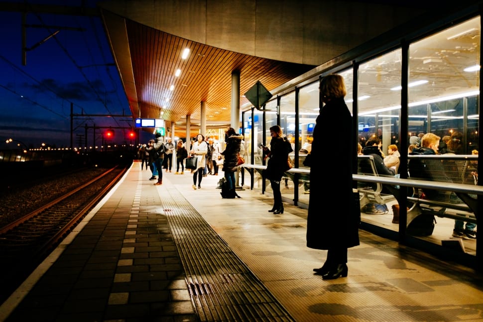 woman in black coat standing in the train station waiting for train to arrive preview