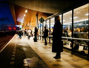 woman in black coat standing in the train station waiting for train to arrive thumbnail