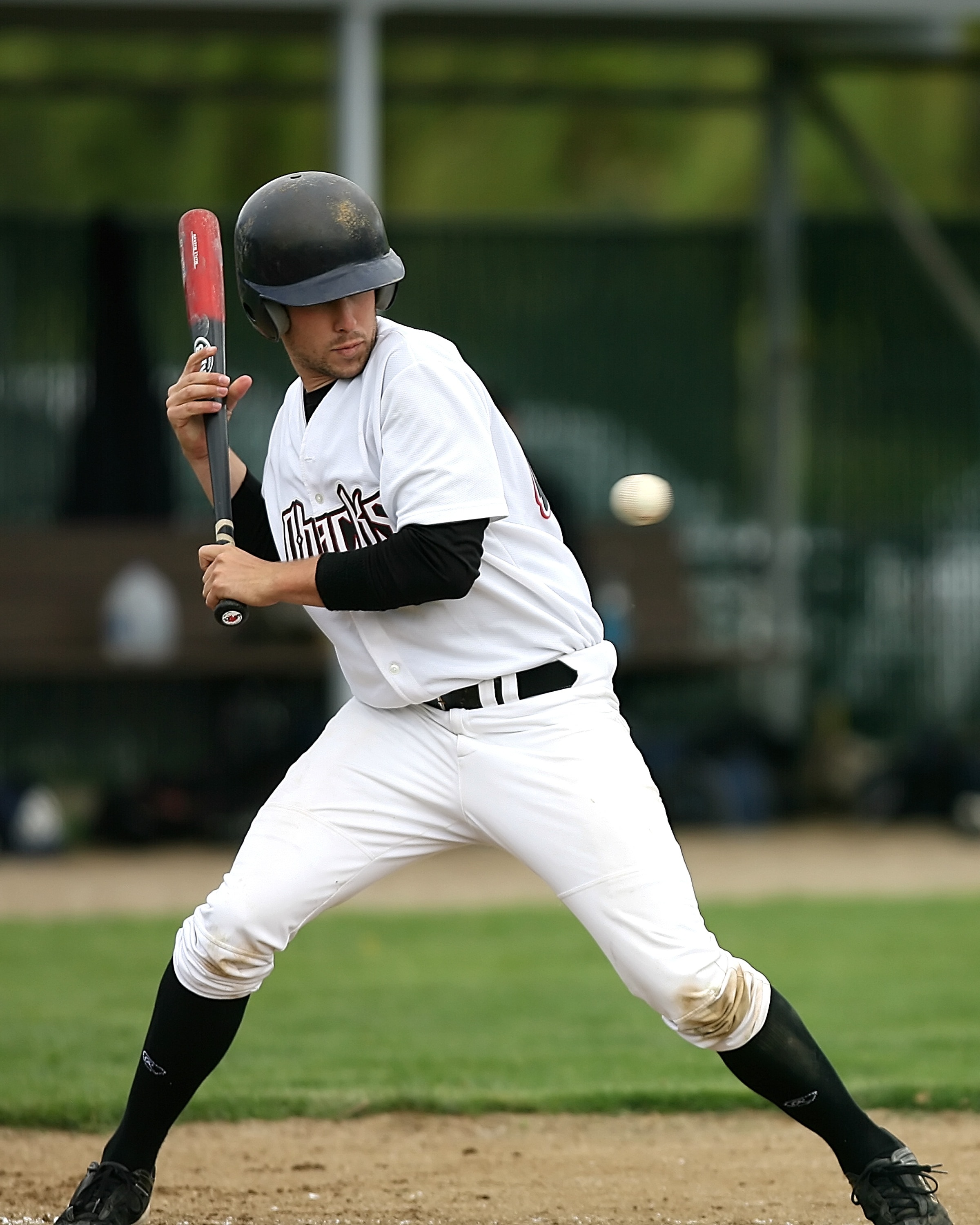 men's white baseball jersey suit and black helmet with baseball bat