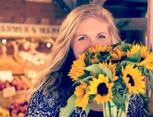 woman holding bunch of sunflowers thumbnail