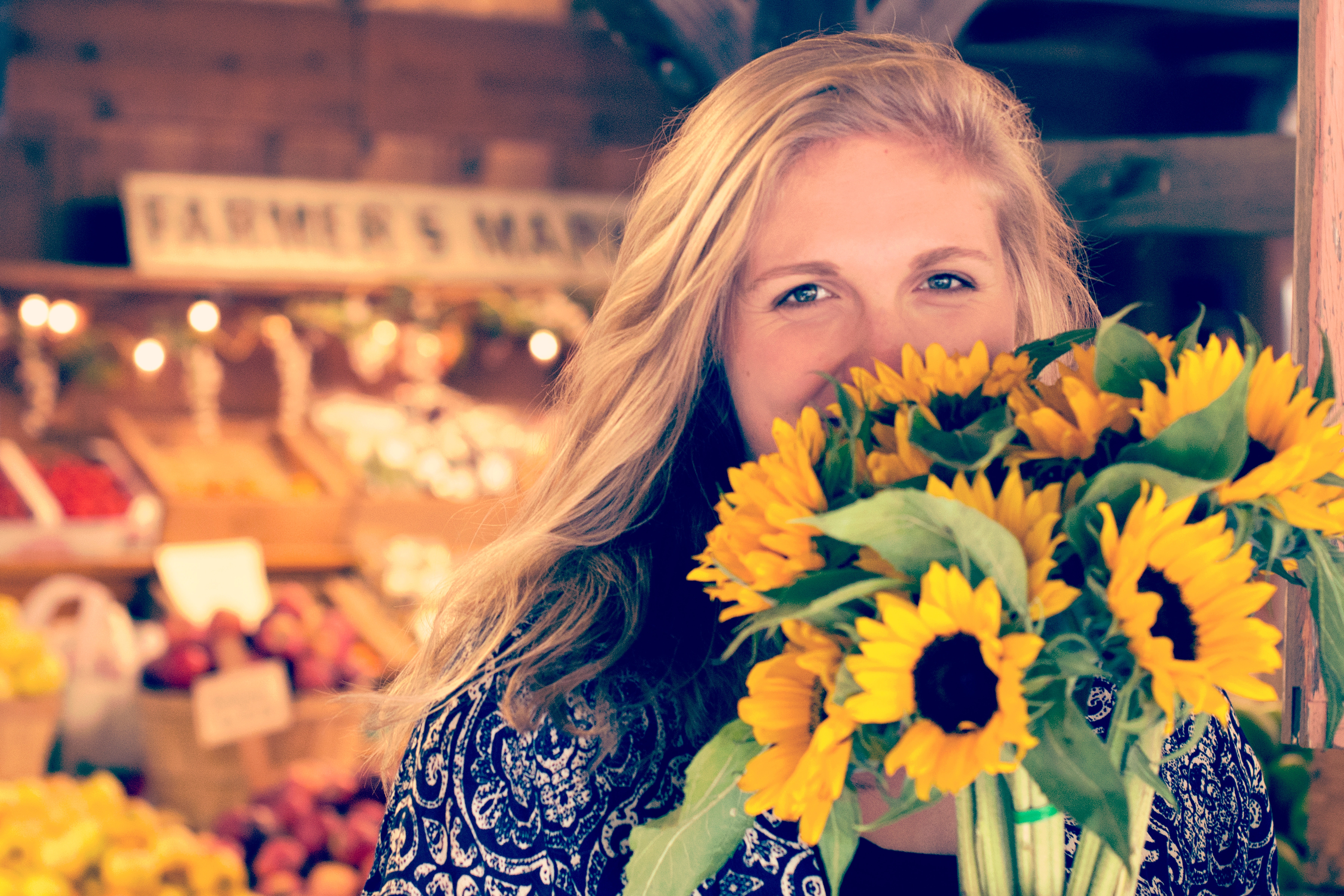 woman holding bunch of sunflowers