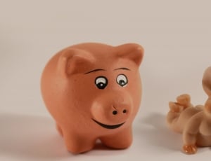 two pink pig figurines on white flooring thumbnail