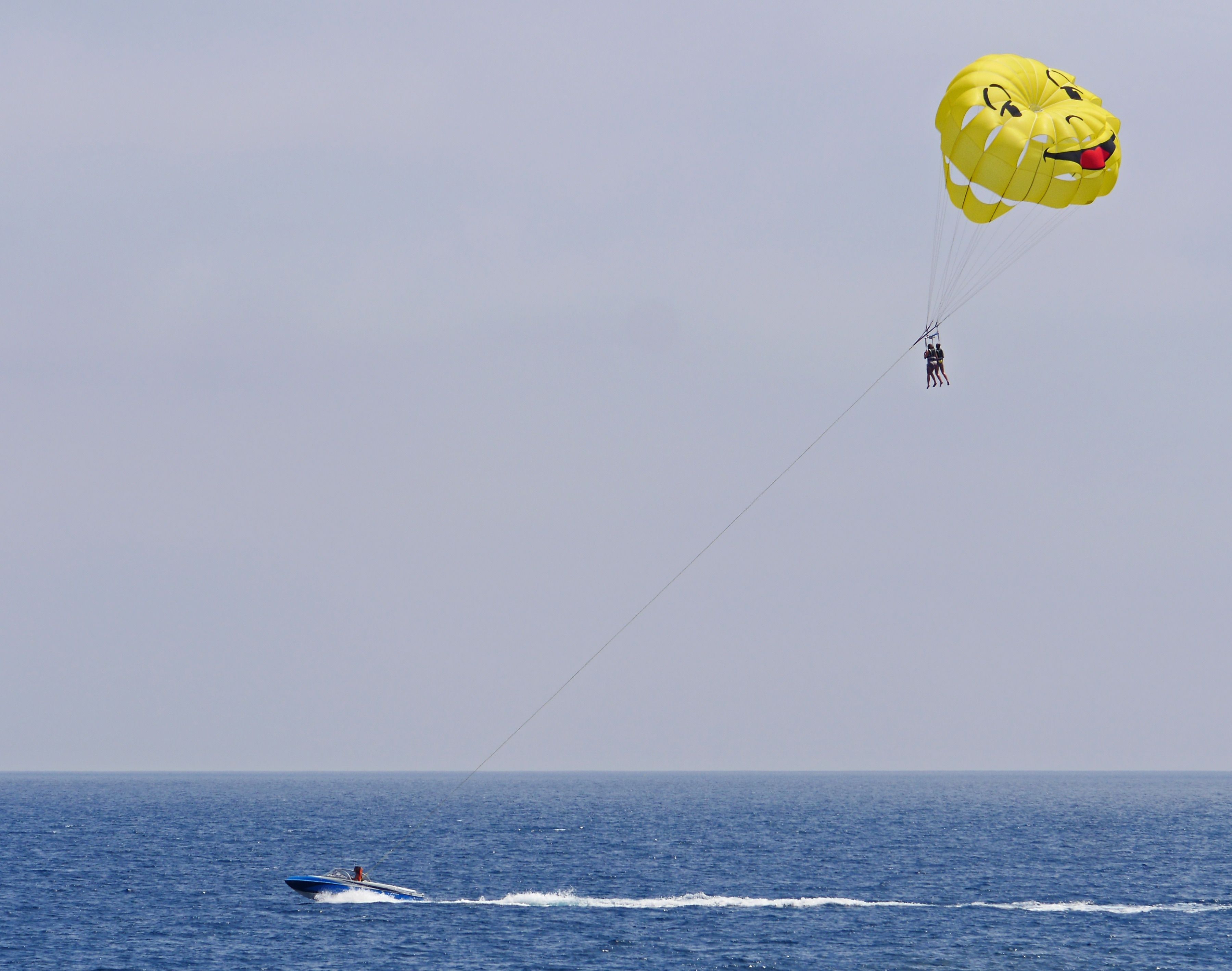 two person parasailing during cloudy skies