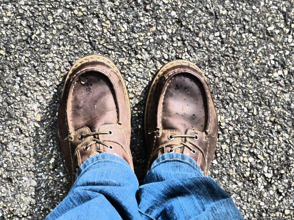 person taking photo of pair of brown leather boat shoes preview