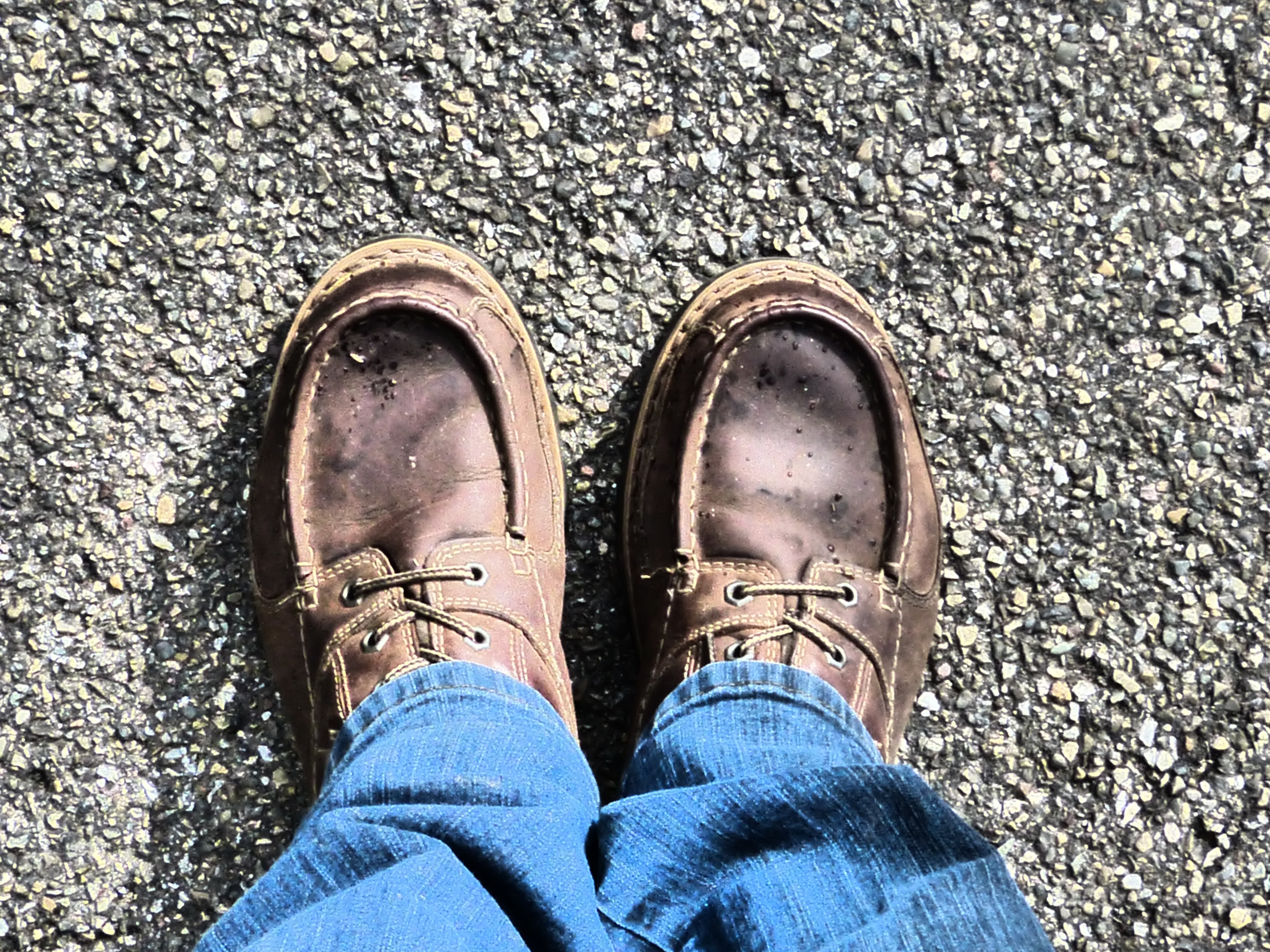 person taking photo of pair of brown leather boat shoes