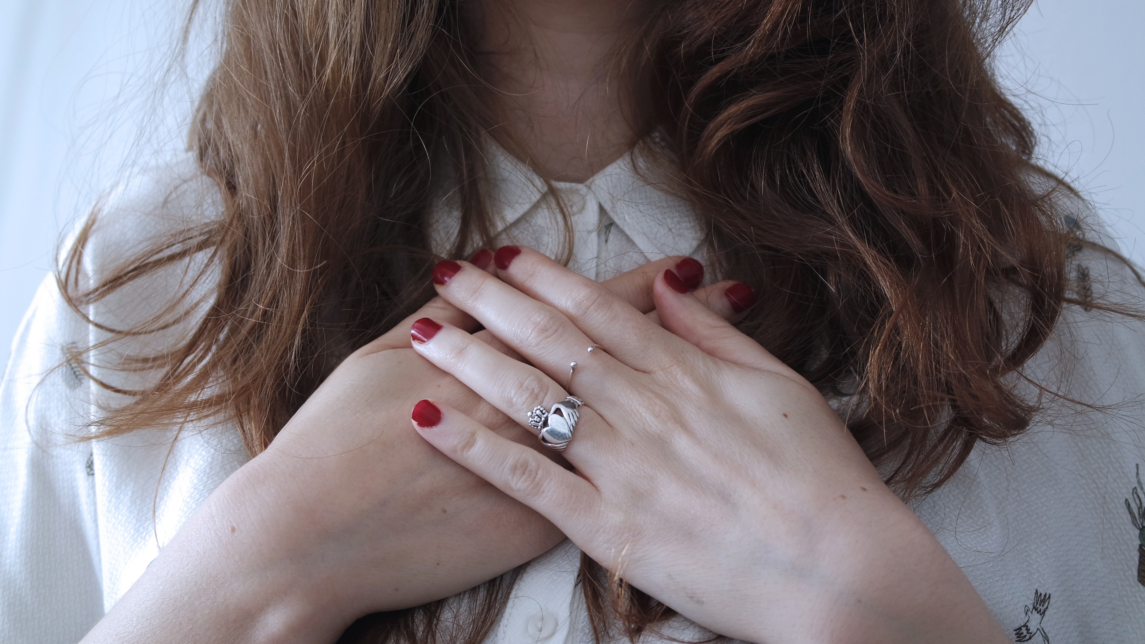 women's silver ring and red manicure
