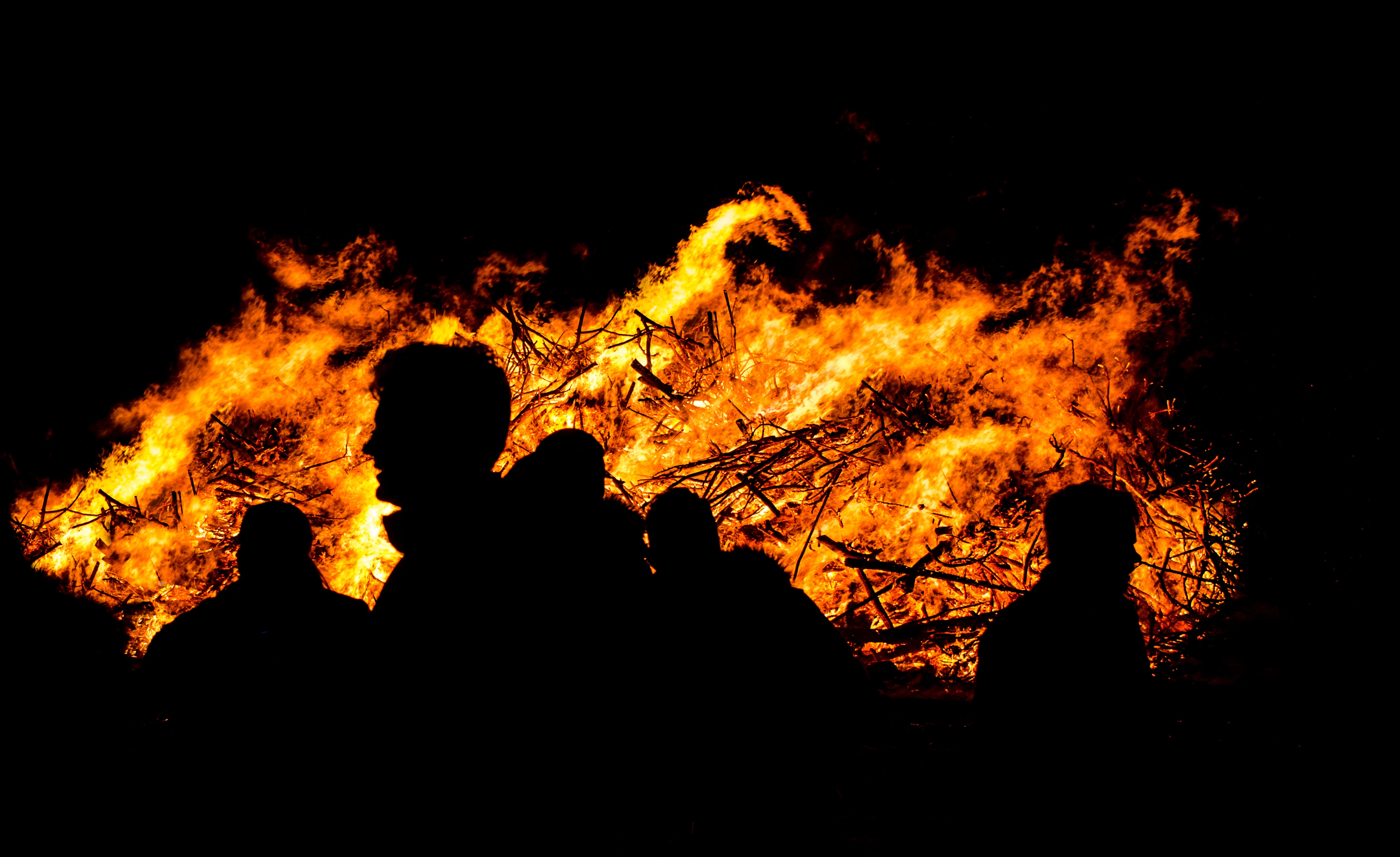 silhouette of people near fire