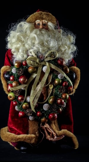 santa claus holding wreath figurine thumbnail