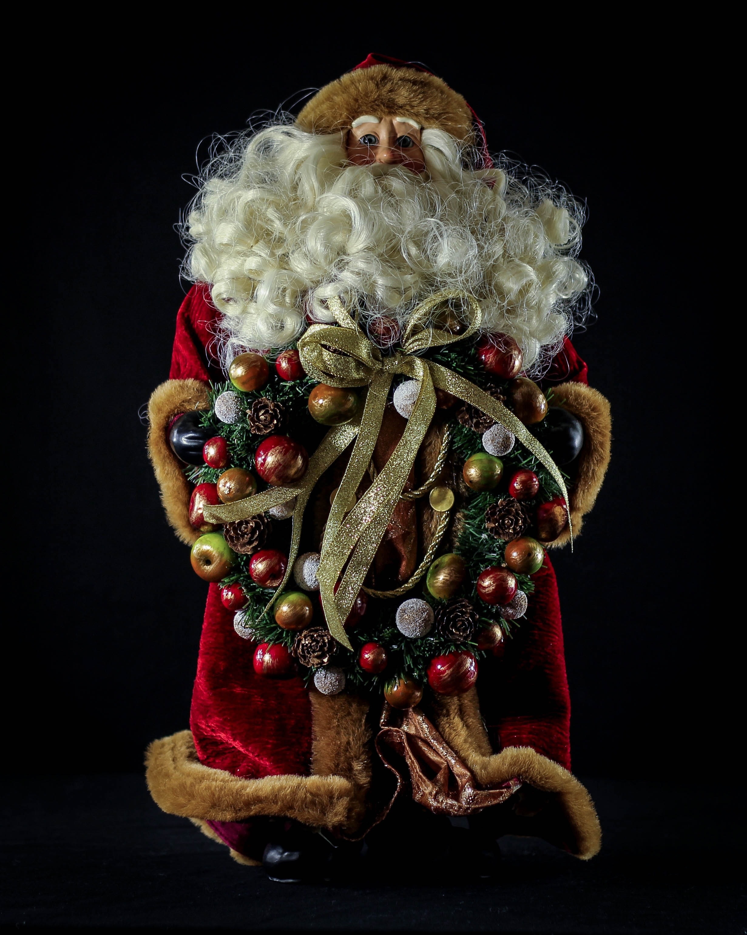 santa claus holding wreath figurine