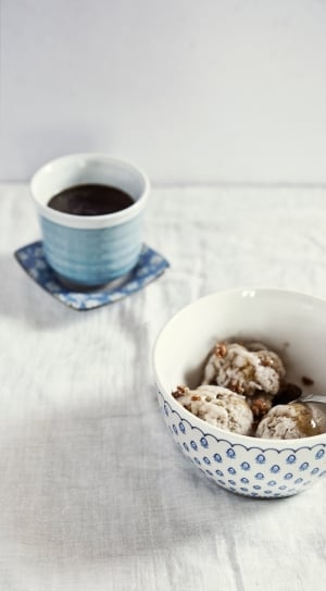white and blue ceramic round bowl with white ice cream and spoon thumbnail