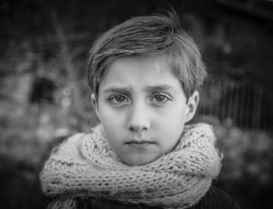 grey scale of boy wearing infinity scarf posing for photo thumbnail