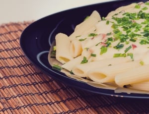 penne pasta dish with white sauce on top and chopped vegetalbe thumbnail