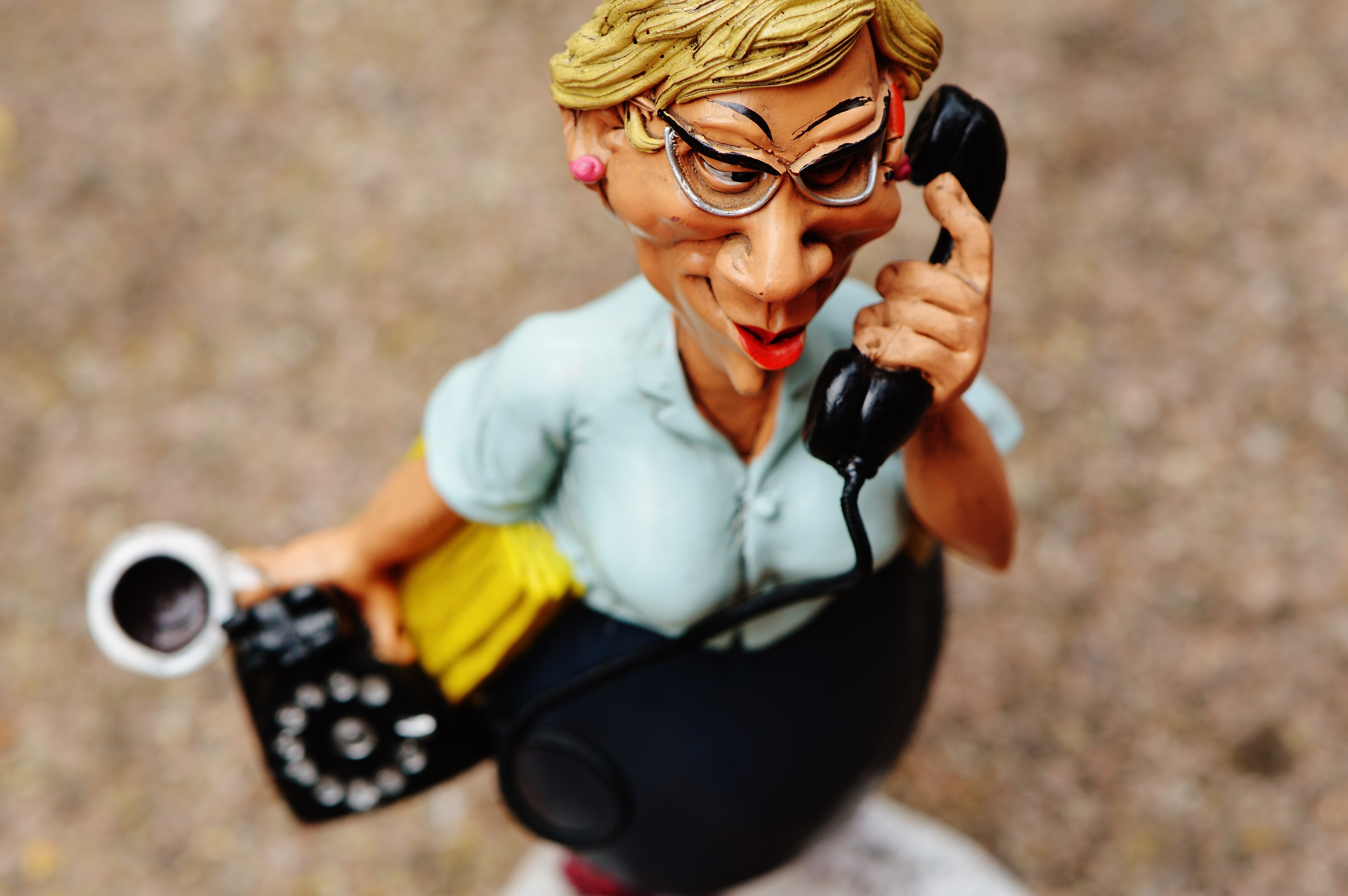 woman answering black telephone caricature figurine